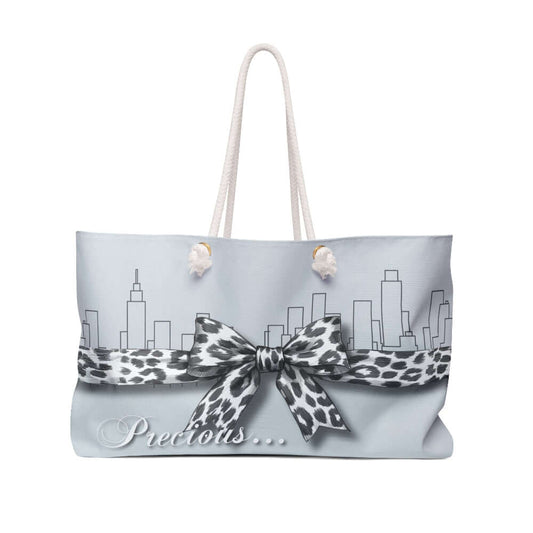 Tote bag with leopard print bow and city skyline design on a light blue background The Palm Beach Proper  Precious Tote