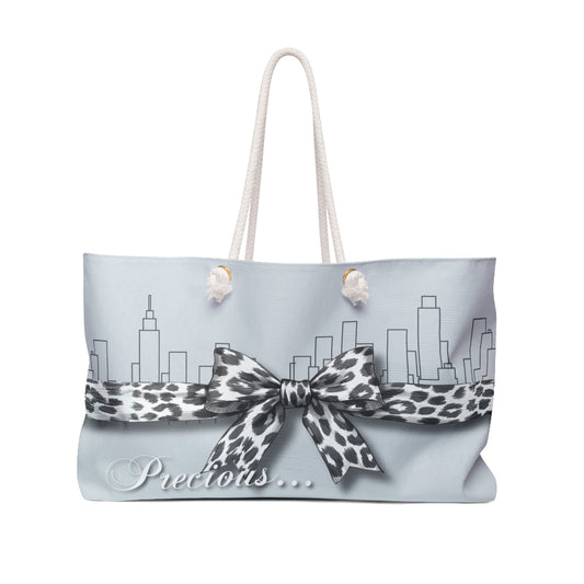 Tote bag with leopard print bow and city skyline design on a light blue background The Palm Beach Proper  Precious Tote