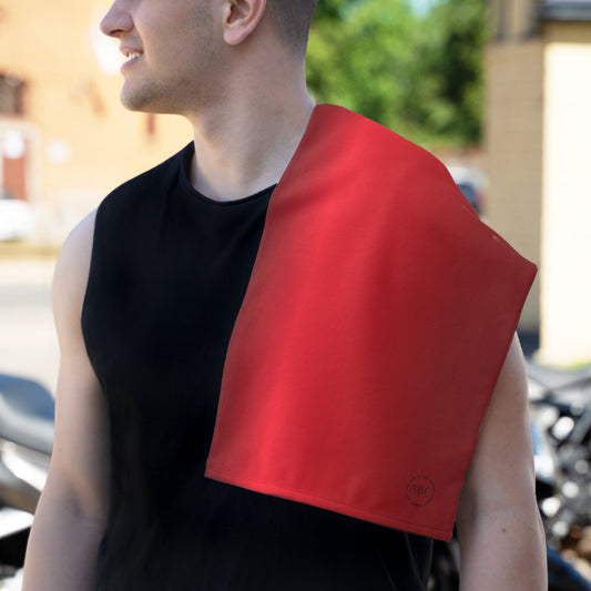 Person wearing a black sleeveless shirt with a PBP red satin burp cloth draped over their shoulder outdoors.